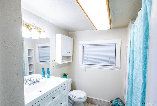 bathroom with tile patterned flooring, vanity, and toilet