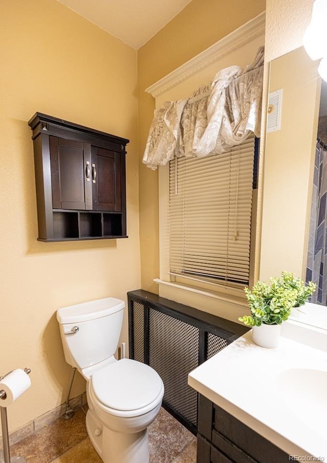 bathroom with vanity, toilet, and radiator heating unit