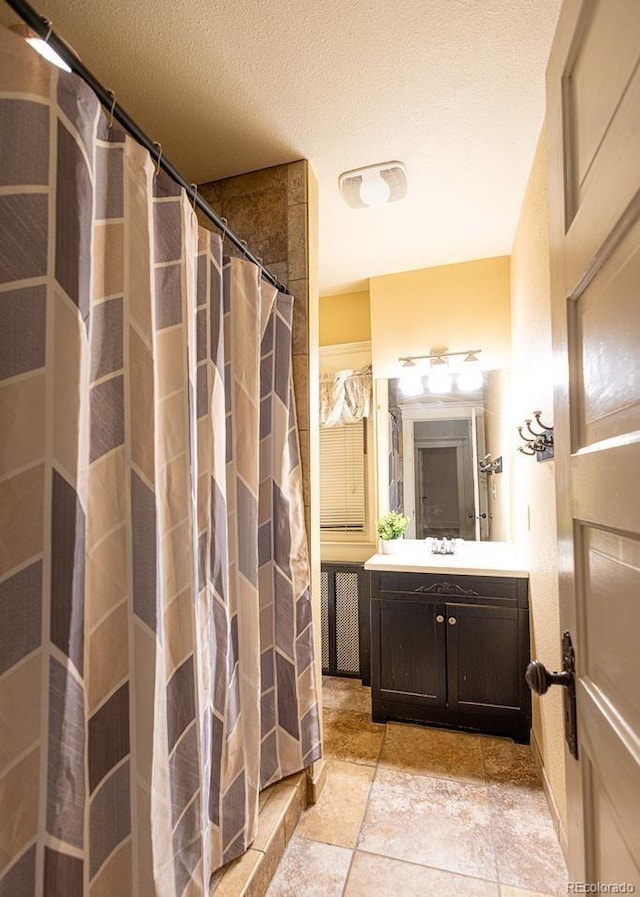 bathroom featuring curtained shower, vanity, and a textured ceiling