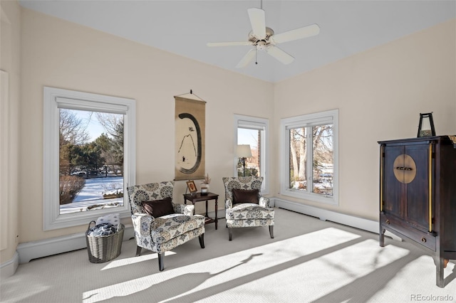 living area with light carpet and ceiling fan