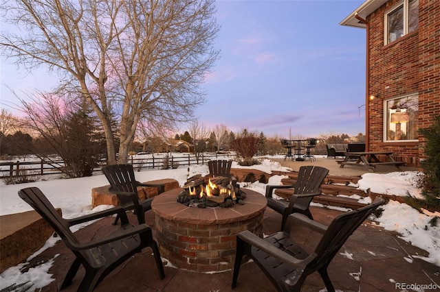 snow covered patio featuring a fire pit