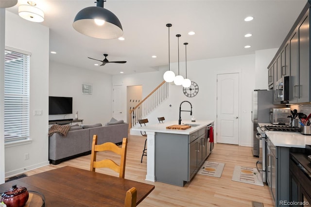 1929 W 165th Way, Broomfield, CO 80023 - kitchen with a sink, appliances with stainless steel finishes, light countertops, light wood finished floors, and a kitchen island with sink