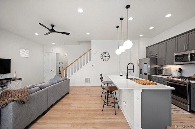 1929 W 165th Way, Broomfield, CO 80023 - kitchen featuring stainless steel appliances, ceiling fan, a kitchen bar, a center island with sink, and recessed lighting