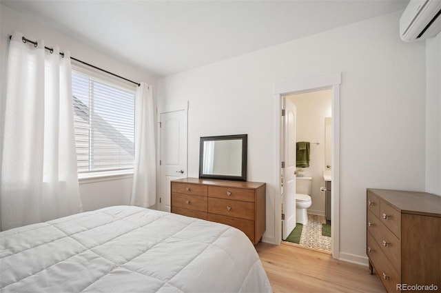 1929 W 165th Way, Broomfield, CO 80023 - bedroom featuring light wood-style flooring, a wall mounted air conditioner, ensuite bath, and baseboards