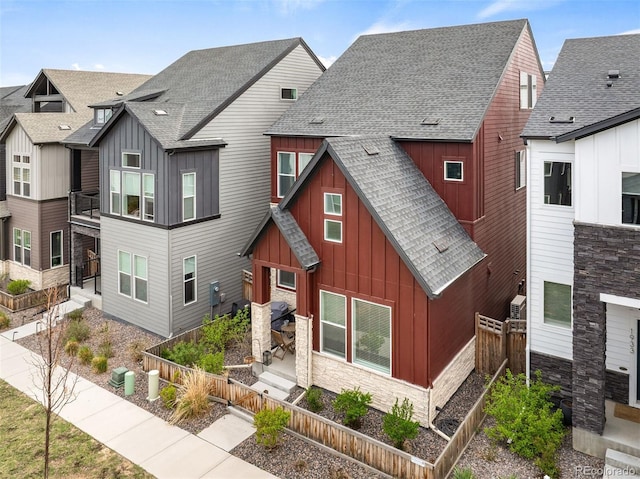 1929 W 165th Way, Broomfield, CO 80023 - view of front of property featuring board and batten siding, stone siding, fence, and roof with shingles