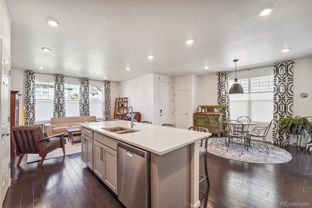 kitchen with stainless steel dishwasher, dark wood-type flooring, and plenty of natural light