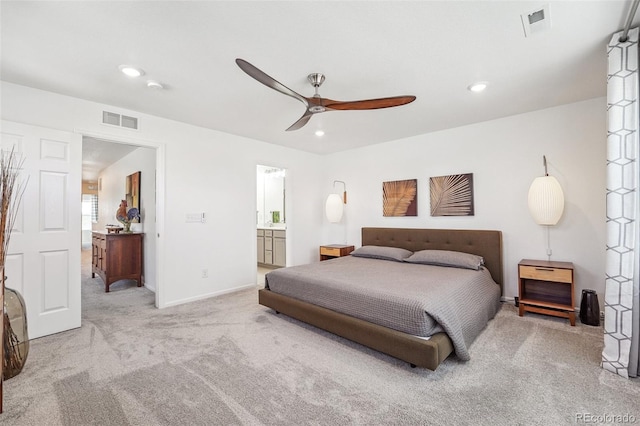 carpeted bedroom with ceiling fan and ensuite bath