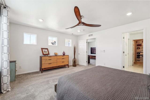 carpeted bedroom with a spacious closet and ceiling fan