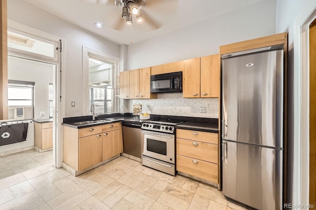 kitchen featuring stainless steel appliances, a sink, dark countertops, ceiling fan, and light brown cabinets