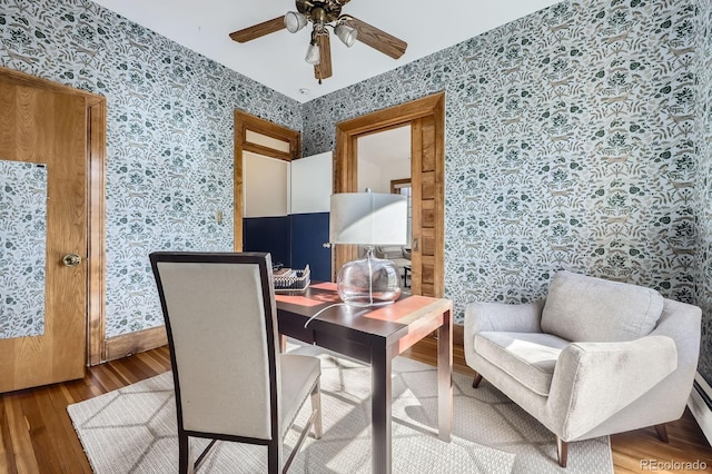 office with wallpapered walls, wood finished floors, a ceiling fan, and baseboards