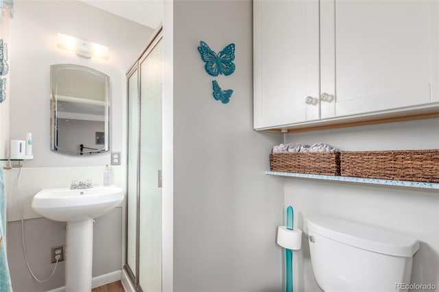 6905 Nelson St, Arvada, CO 80004 - bathroom featuring toilet, a sink, and a stall shower