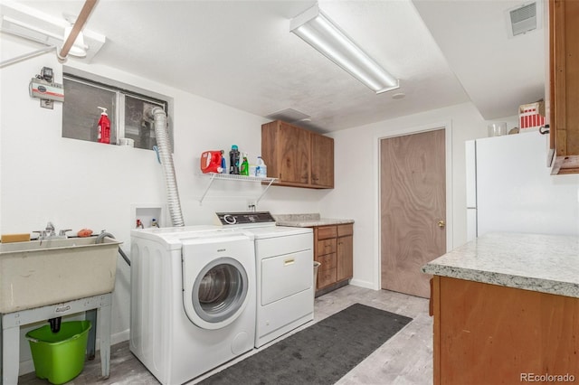 6905 Nelson St, Arvada, CO 80004 - laundry room featuring visible vents, light wood-style flooring, cabinet space, and washing machine and clothes dryer