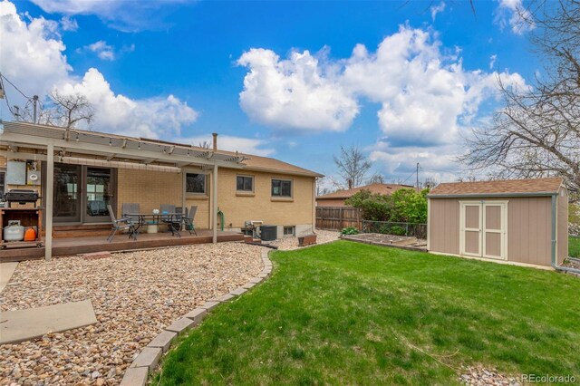 6905 Nelson St, Arvada, CO 80004 - rear view of house with fence, a storage unit, brick siding, a lawn, and an outdoor structure