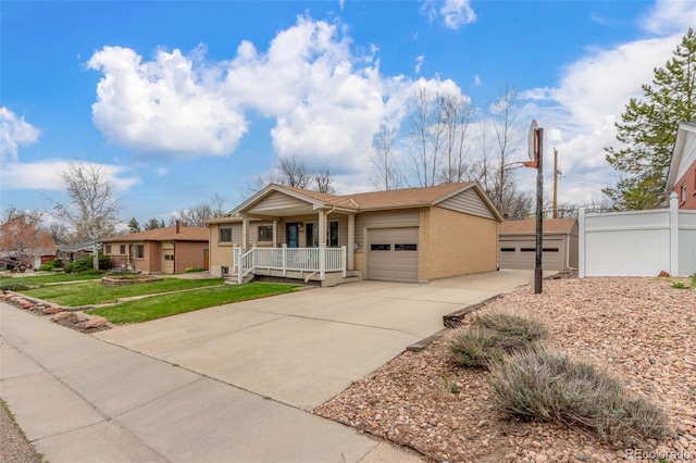 6905 Nelson St, Arvada, CO 80004 - ranch-style house with brick siding, a garage, a porch, a front yard, and driveway