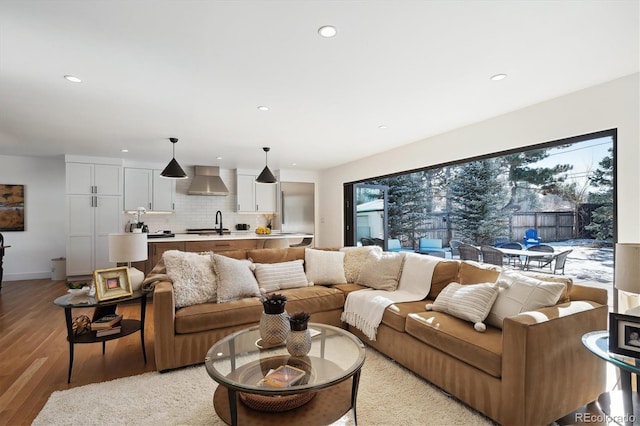 living room with sink, a wealth of natural light, and light hardwood / wood-style flooring