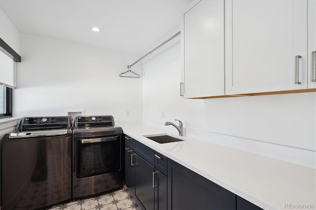 clothes washing area with cabinets, sink, and independent washer and dryer