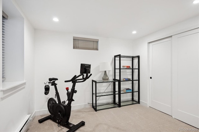 workout area featuring a baseboard radiator and light colored carpet