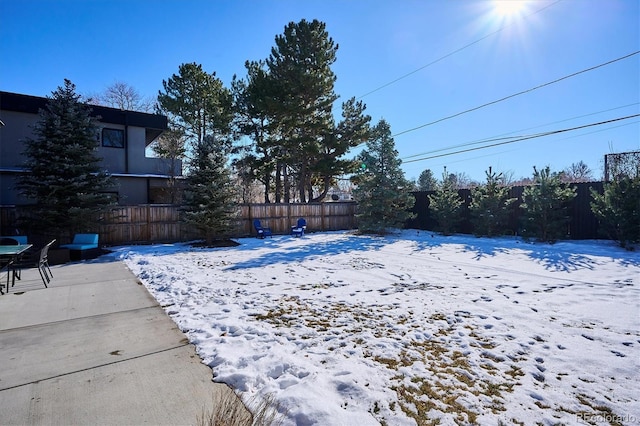 snowy yard featuring a patio area