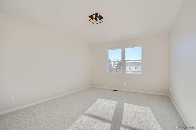 empty room with visible vents, baseboards, and carpet floors