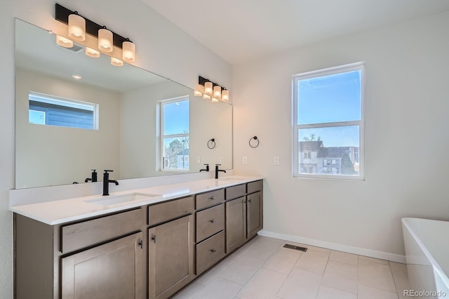 full bathroom featuring a sink, visible vents, baseboards, and double vanity