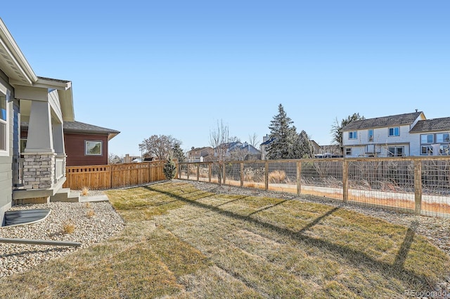 view of yard with a fenced backyard and a residential view