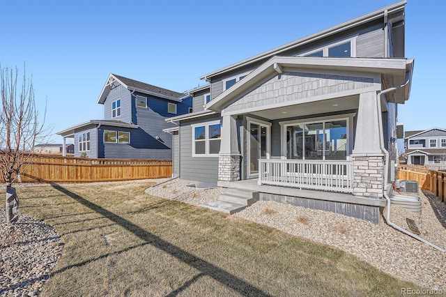 rear view of property with a yard, a porch, and fence