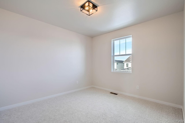 carpeted spare room with baseboards and visible vents