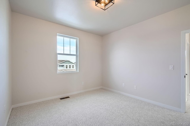 empty room featuring visible vents, baseboards, and carpet floors