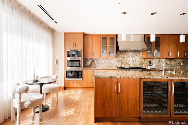 1133 14th St Unit 3420, Denver, CO 80202 - kitchen with wall chimney range hood, oven, beverage cooler, decorative backsplash, and light wood-style floors