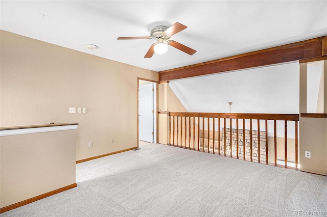 empty room with carpet, ceiling fan, lofted ceiling with beams, and baseboards