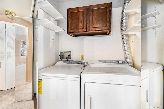 laundry area featuring light carpet, cabinet space, and washer and dryer