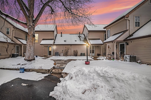 snow covered back of property with central AC