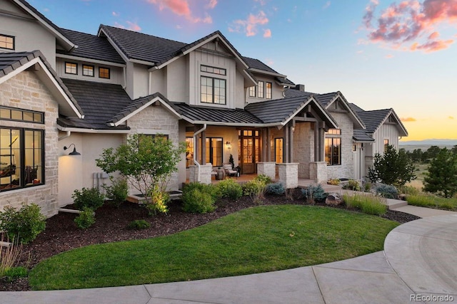 view of front of house with a patio and a lawn