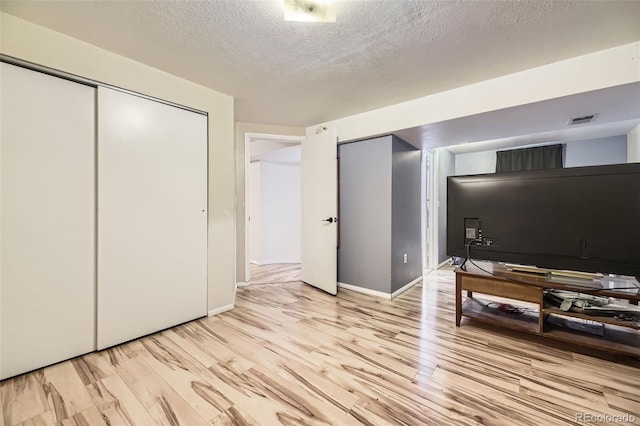 14742 E Radcliff Pl, Aurora, CO 80015 - bedroom with light wood-type flooring, a textured ceiling, and baseboards