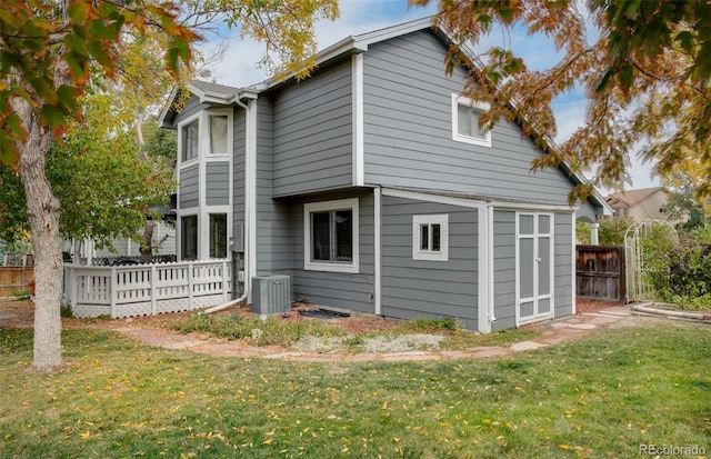 rear view of property with a yard and central AC unit