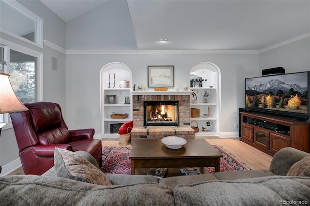 living room featuring a brick fireplace, light hardwood / wood-style floors, and built in features