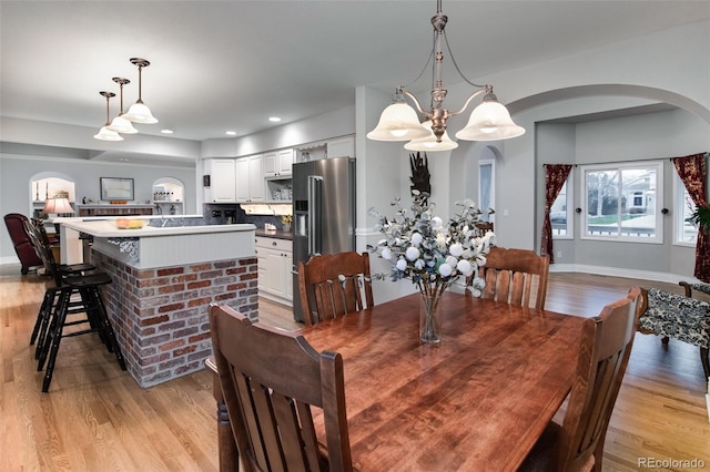 dining room featuring light wood-type flooring and a notable chandelier