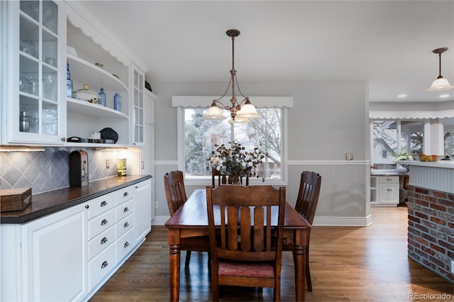 dining area featuring dark wood-type flooring and a chandelier