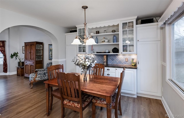 dining space with a notable chandelier and dark hardwood / wood-style floors