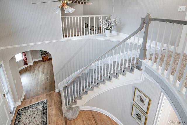 stairs with ceiling fan and hardwood / wood-style floors