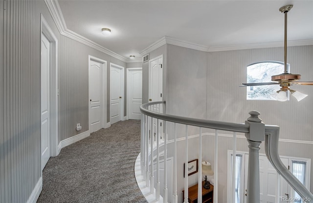 hallway with ornamental molding and carpet floors