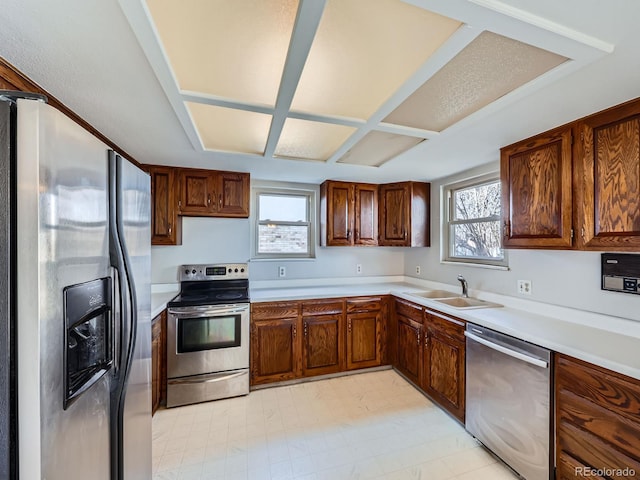 kitchen featuring a wealth of natural light, stainless steel appliances, a sink, and light countertops