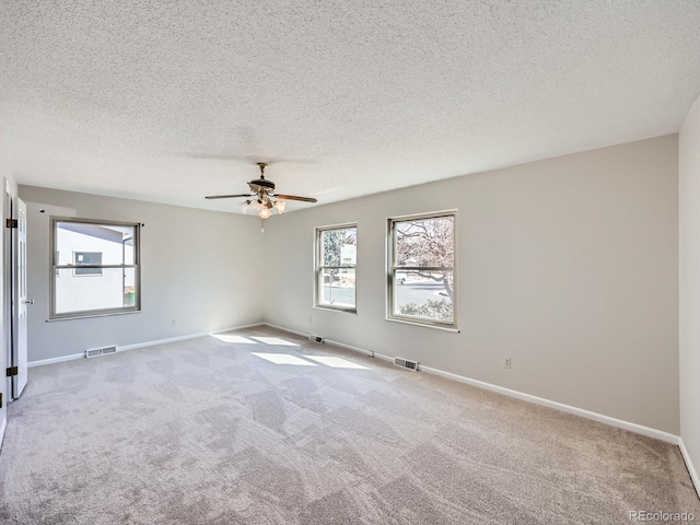 empty room with baseboards, visible vents, and carpet flooring