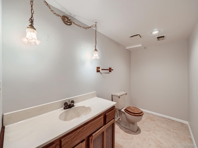 bathroom featuring toilet, baseboards, visible vents, and vanity