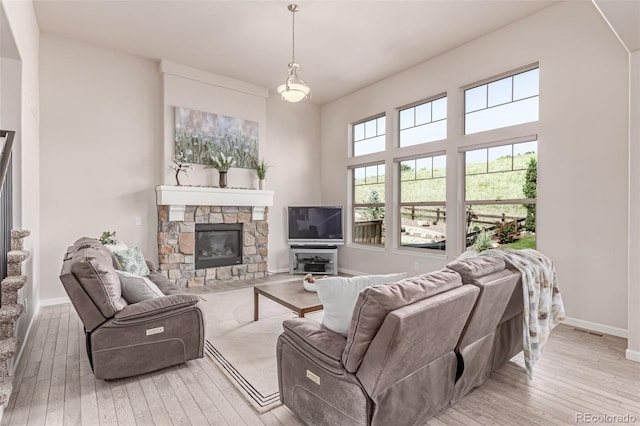 15647 Weaver Gulch Dr, Morrison, CO 80465 - living room featuring a fireplace and light wood-style flooring