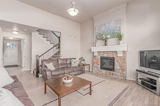 15647 Weaver Gulch Dr, Morrison, CO 80465 - living area featuring wood finished floors, stairs, and a stone fireplace
