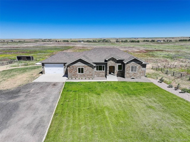 view of front of property featuring a rural view, a garage, and a front lawn