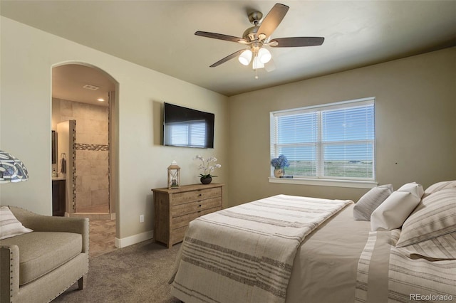 carpeted bedroom with ceiling fan and ensuite bath