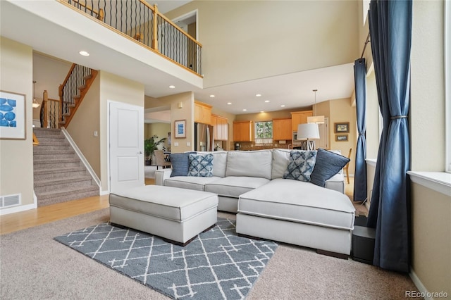 9158 Forest St, Firestone, CO 80504 - living area featuring stairs, a high ceiling, carpet floors, baseboards, and recessed lighting