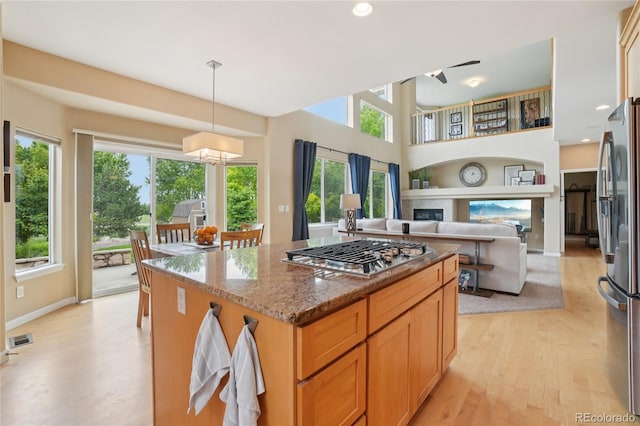 9158 Forest St, Firestone, CO 80504 - kitchen featuring stainless steel appliances, light wood finished floors, stone counters, a kitchen island, and open floor plan